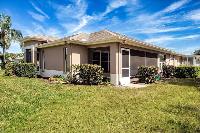 1020 New Winsor Loop Unit 46, Sun City Center, FL 33573 - view of home's exterior with stucco siding, a yard, and a sunroom