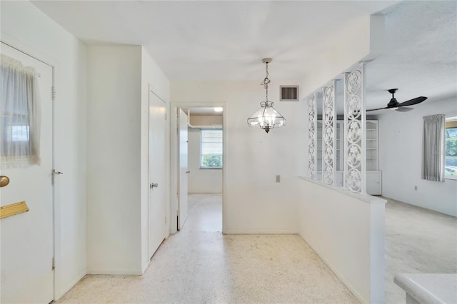 hall featuring visible vents and light speckled floor