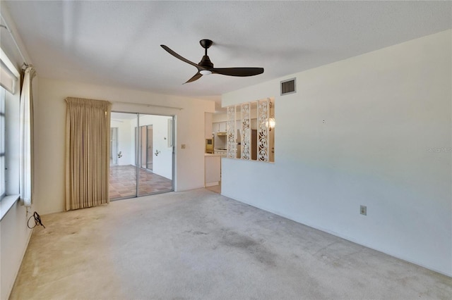 interior space with light carpet, visible vents, and ceiling fan