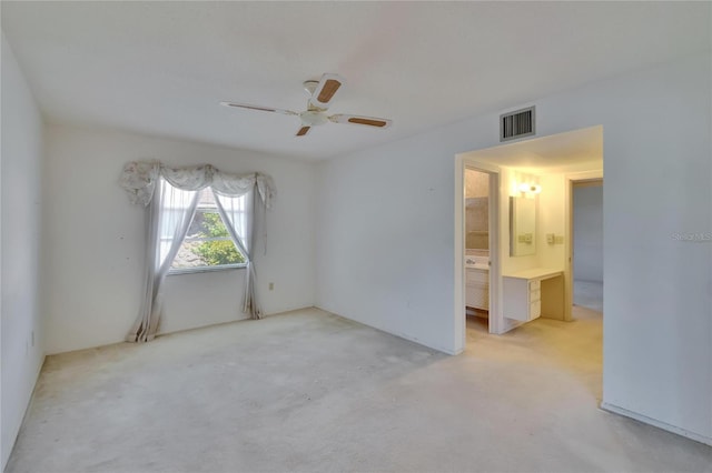 spare room featuring carpet floors, visible vents, and a ceiling fan
