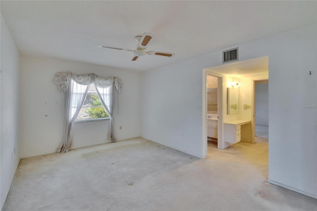 empty room with carpet floors, visible vents, and a ceiling fan