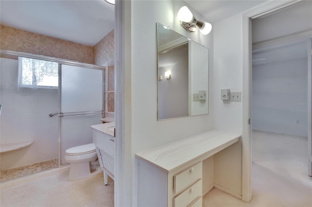 bathroom with a shower with shower door, toilet, and vanity