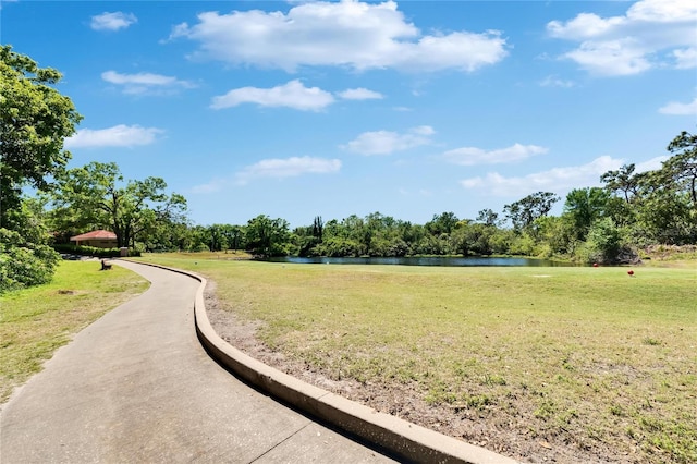 view of home's community with a water view and a lawn
