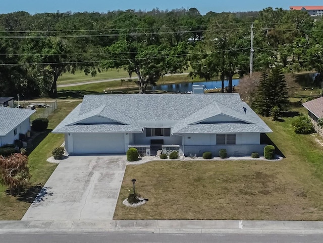 view of front facade with driveway, a garage, a front lawn, and roof with shingles