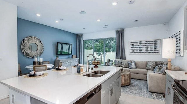 kitchen featuring open floor plan, dishwasher, light countertops, electric range, and a sink