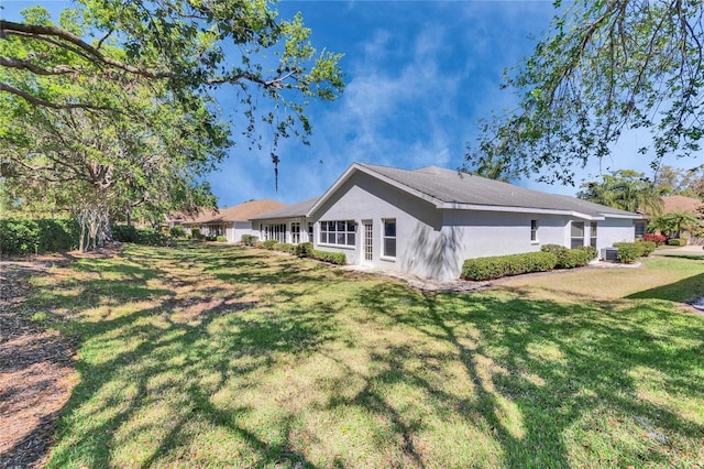 1034 Mcdaniel St Unit 1034, Sun City Center, FL 33573 - back of house with stucco siding and a lawn