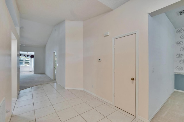 1034 Mcdaniel St Unit 1034, Sun City Center, FL 33573 - hall featuring light tile patterned floors, visible vents, baseboards, vaulted ceiling, and light carpet