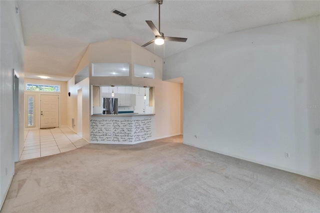 1034 Mcdaniel St Unit 1034, Sun City Center, FL 33573 - unfurnished living room featuring tile patterned flooring, visible vents, ceiling fan, carpet floors, and high vaulted ceiling