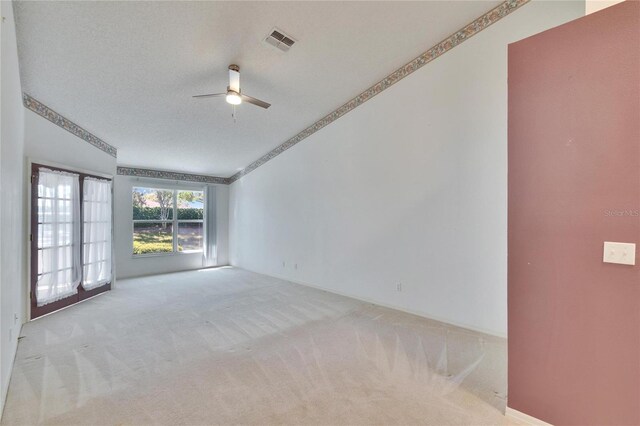 1034 Mcdaniel St Unit 1034, Sun City Center, FL 33573 - carpeted empty room featuring visible vents, a textured ceiling, a ceiling fan, and vaulted ceiling