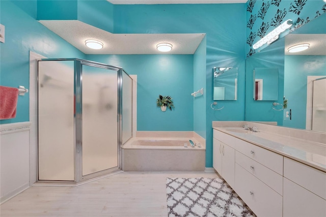 1034 Mcdaniel St Unit 1034, Sun City Center, FL 33573 - full bathroom with vanity, wood finished floors, a stall shower, a textured ceiling, and a garden tub