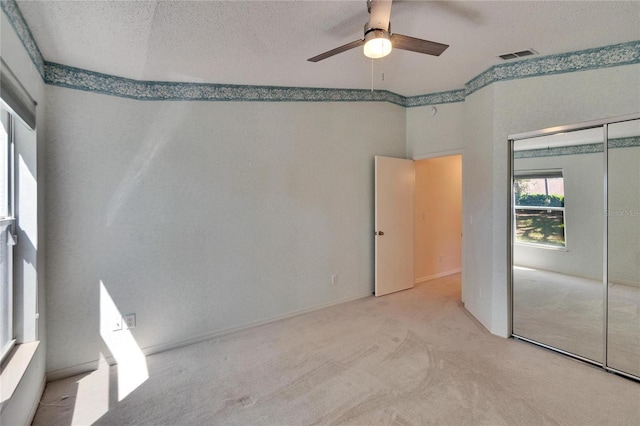 1034 Mcdaniel St Unit 1034, Sun City Center, FL 33573 - unfurnished bedroom with visible vents, carpet floors, ceiling fan, a closet, and a textured ceiling