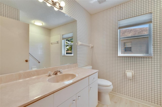 1034 Mcdaniel St Unit 1034, Sun City Center, FL 33573 - bathroom with vanity, a textured ceiling, wood finished floors, walk in shower, and toilet
