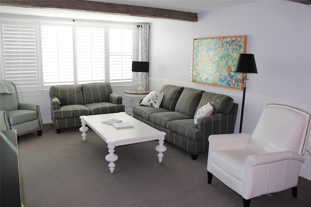 living room with a wainscoted wall, carpet flooring, and beamed ceiling