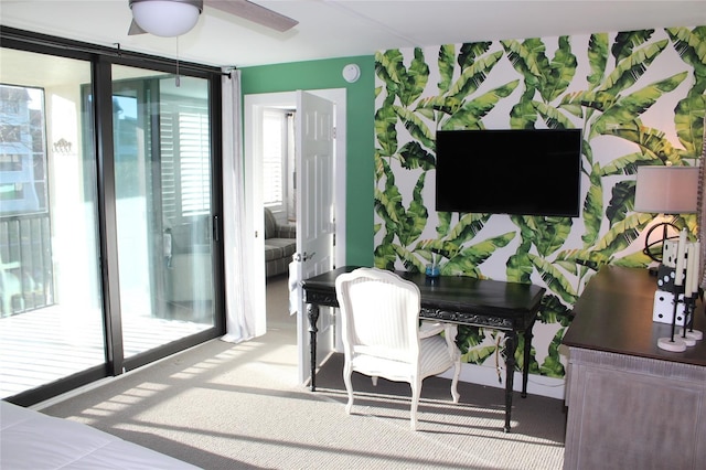 office area featuring carpet floors, ceiling fan, and expansive windows