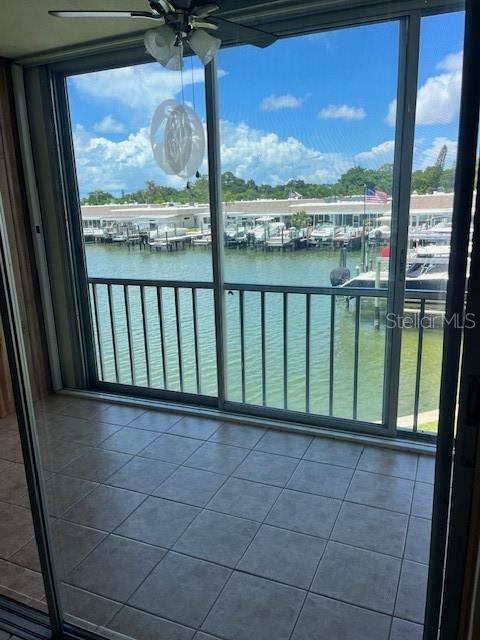 balcony featuring ceiling fan and a water view