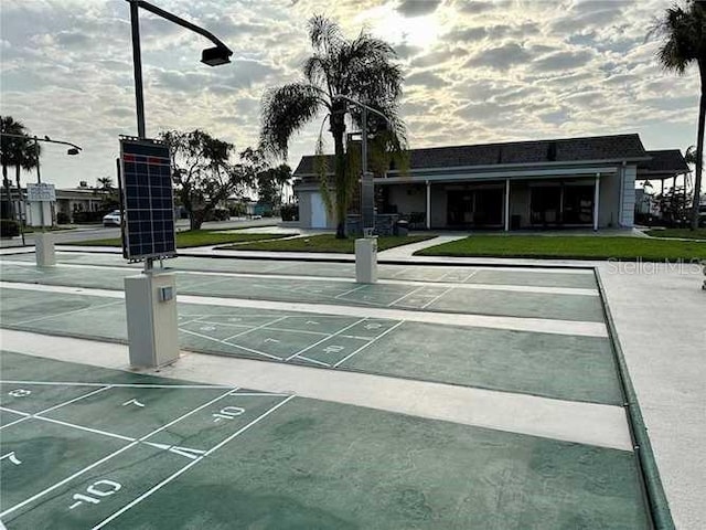 view of community featuring shuffleboard and a yard