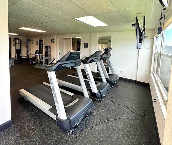 gym featuring baseboards and a paneled ceiling