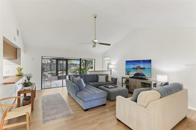 living area featuring light wood-style flooring, a ceiling fan, visible vents, and high vaulted ceiling