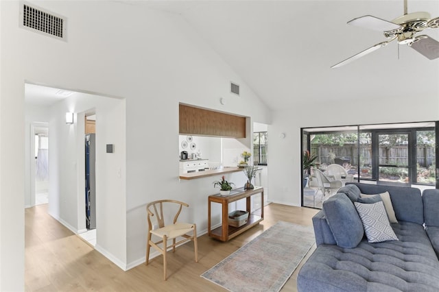 living room with light wood-style flooring, visible vents, high vaulted ceiling, and ceiling fan