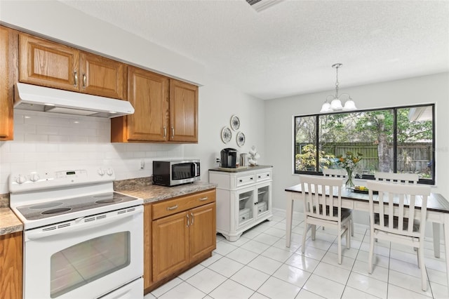 kitchen featuring under cabinet range hood, stainless steel microwave, brown cabinets, and white electric range oven