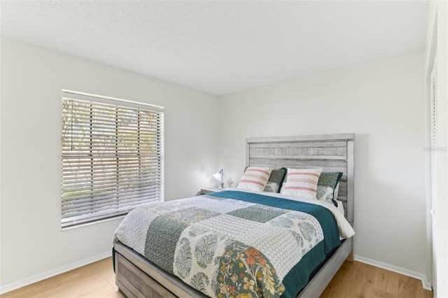 bedroom featuring baseboards and light wood-style floors