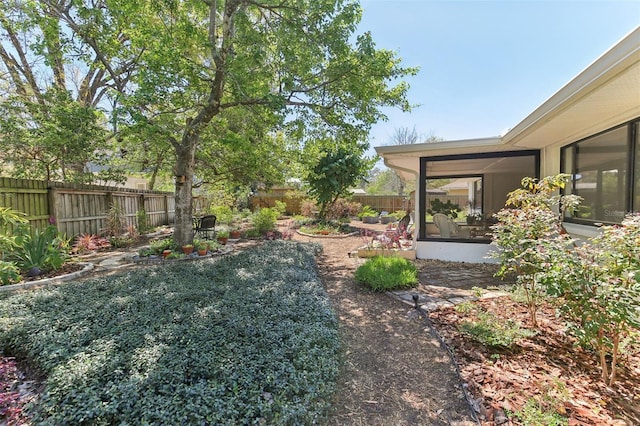 view of yard featuring a fenced backyard and a sunroom