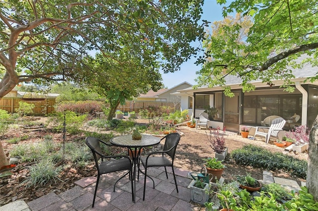 view of patio / terrace with fence and a sunroom