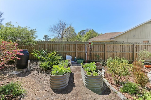 view of yard with a vegetable garden and fence