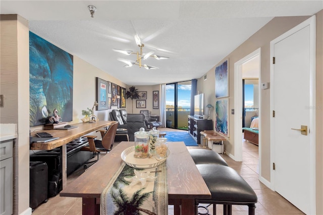 dining space with light tile patterned floors, an inviting chandelier, and floor to ceiling windows