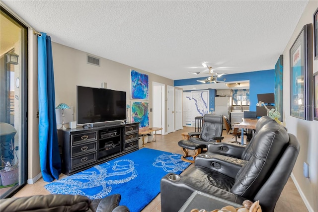 living room featuring visible vents, baseboards, and a textured ceiling