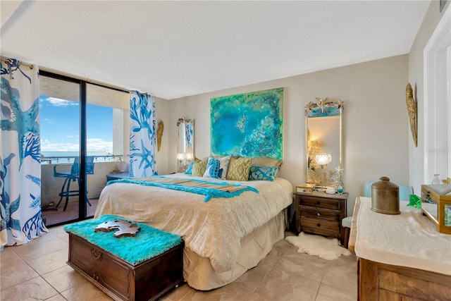 bedroom featuring access to exterior, light tile patterned floors, and floor to ceiling windows