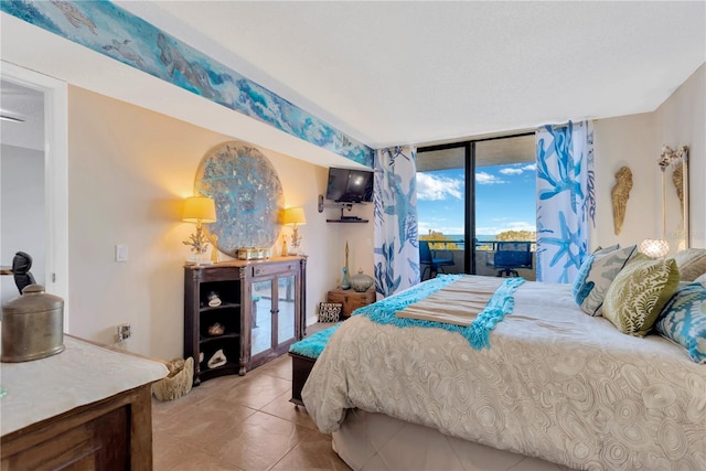 bedroom featuring light tile patterned floors, floor to ceiling windows, and access to outside