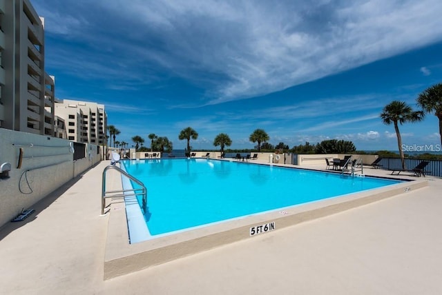 community pool featuring a patio and fence