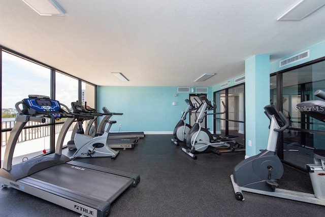 gym featuring baseboards, visible vents, and a textured ceiling