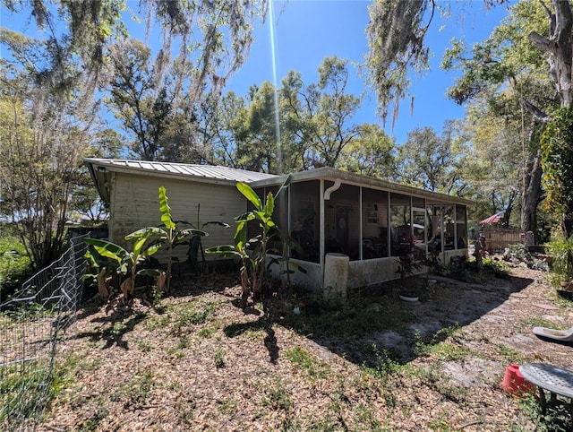 rear view of property with metal roof and a sunroom