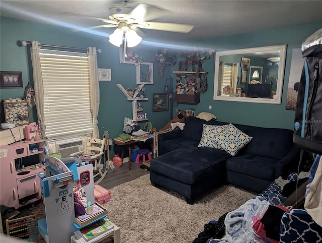 living room with cooling unit, wood finished floors, and ceiling fan