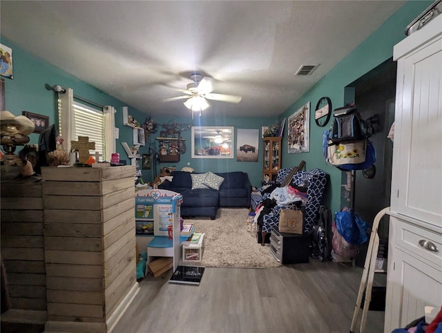 bedroom featuring ceiling fan, visible vents, and wood finished floors