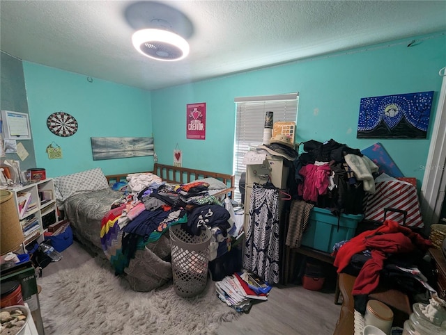 bedroom featuring wood finished floors and a textured ceiling