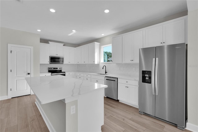 17526 SW 25th Cir, Ocala, FL 34473 - kitchen featuring appliances with stainless steel finishes, a center island, white cabinetry, light stone countertops, and recessed lighting