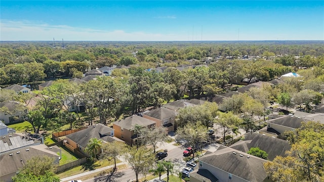 drone / aerial view featuring a residential view and a wooded view