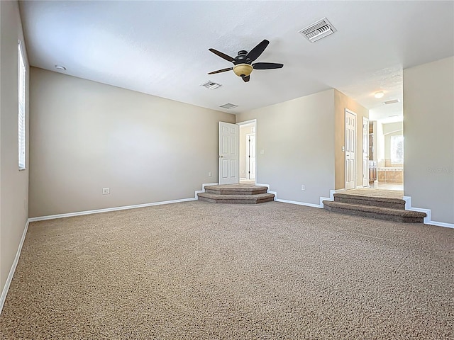 unfurnished living room with carpet flooring, baseboards, and visible vents