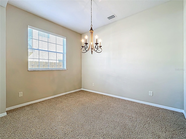 empty room with a notable chandelier, visible vents, and baseboards