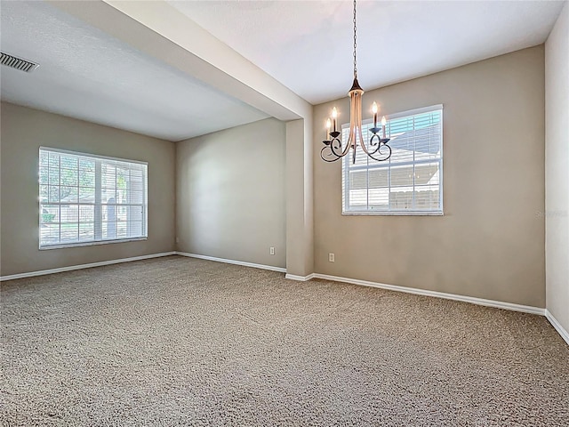 empty room with visible vents, baseboards, a notable chandelier, and a healthy amount of sunlight