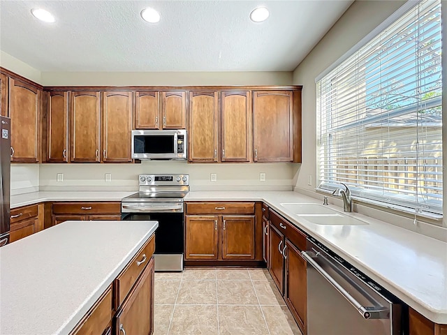 kitchen with light countertops, light tile patterned floors, recessed lighting, stainless steel appliances, and a sink