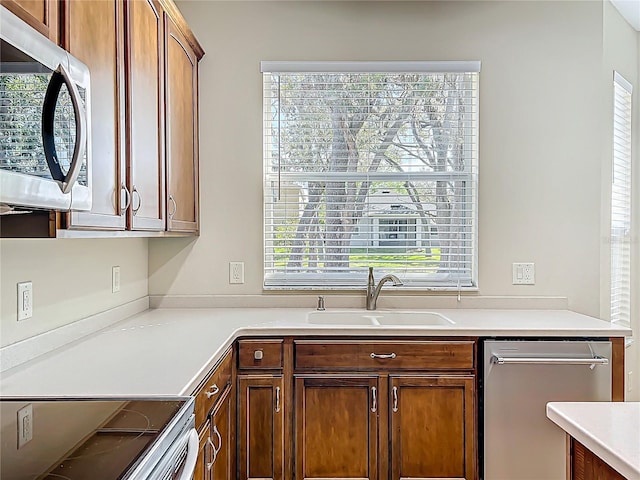 kitchen with a sink, appliances with stainless steel finishes, and light countertops