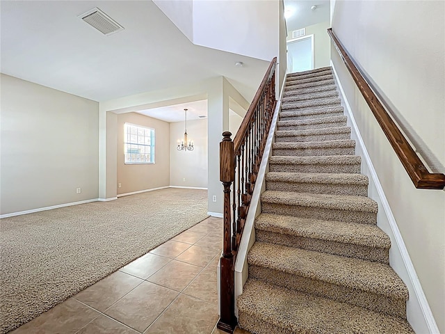 stairway featuring tile patterned floors, visible vents, carpet, and a chandelier