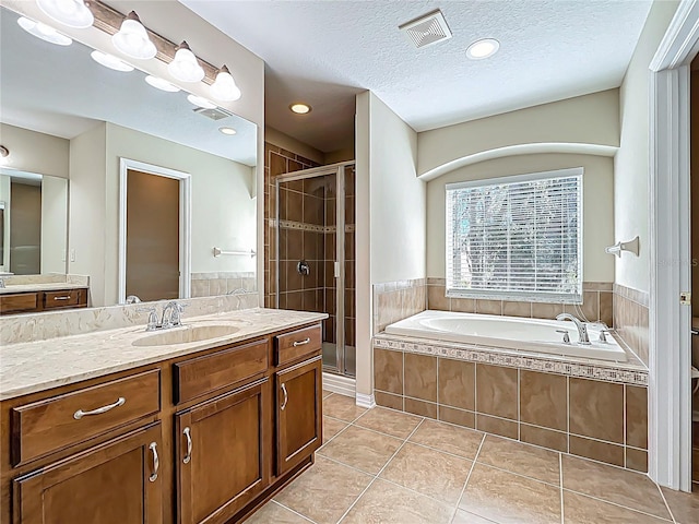 full bathroom with tile patterned floors, visible vents, a stall shower, a textured ceiling, and a bath