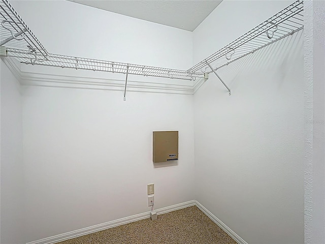 washroom with electric panel, dark carpet, and baseboards