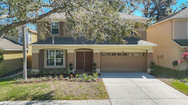 view of front of home with stucco siding, driveway, roof with shingles, and an attached garage