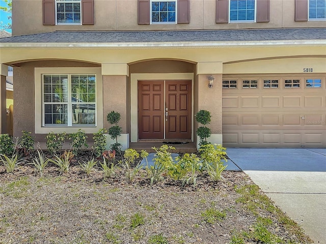 property entrance with stucco siding, an attached garage, and roof with shingles